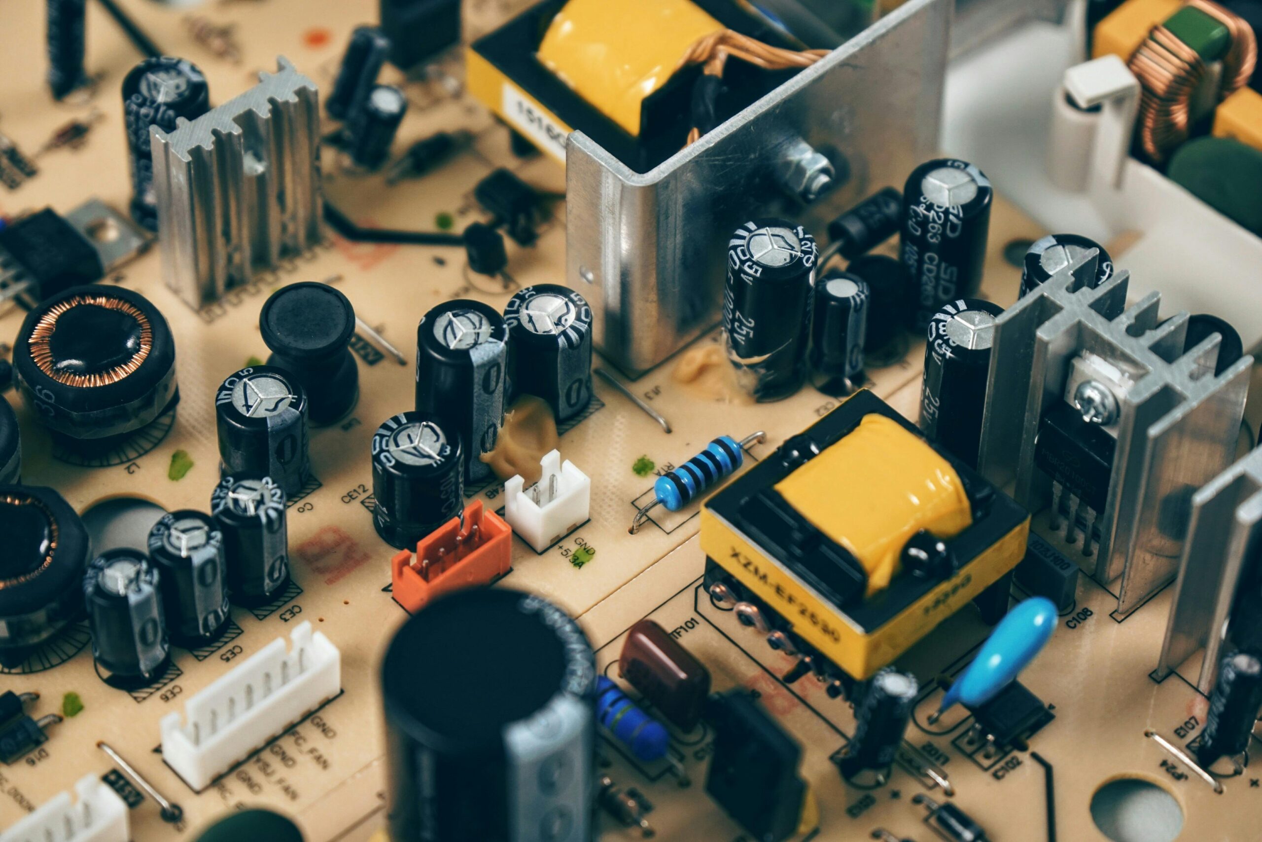 Detailed shot of capacitors and resistors on a circuit board, showcasing modern technology.